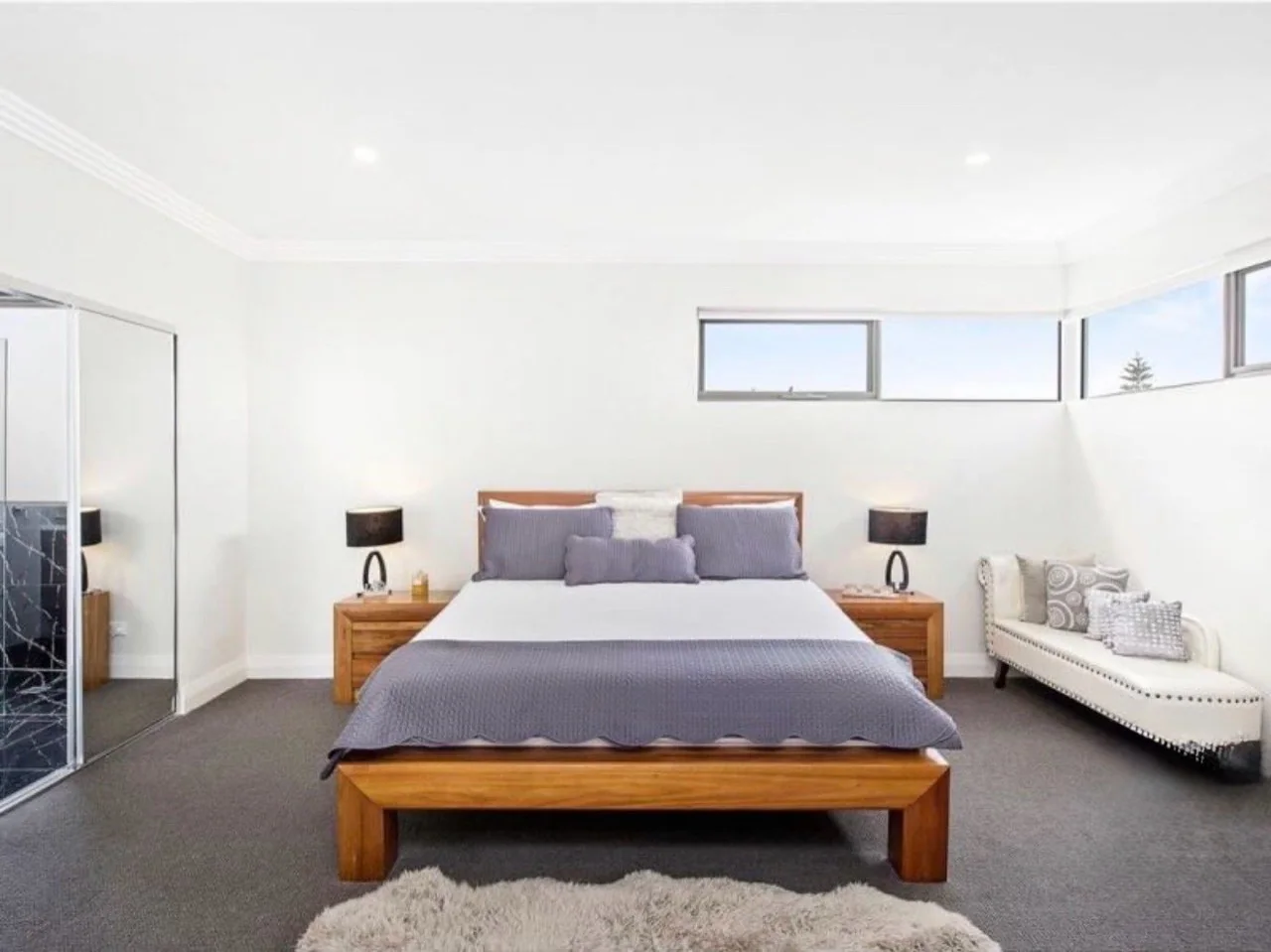 Bedroom with white walls, decorative cornice and a charcoal carpet