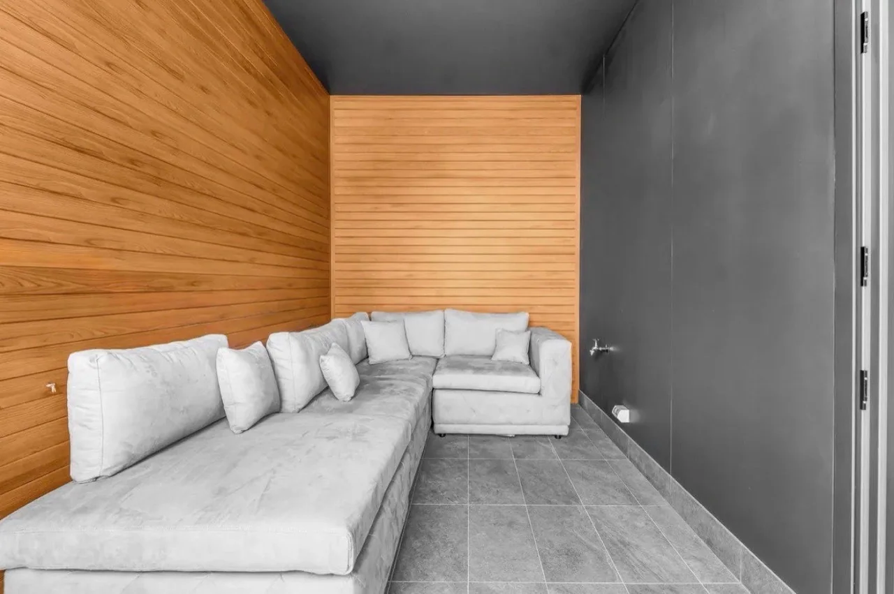 Covered sitting area with dark grey feature walls and timber panelling