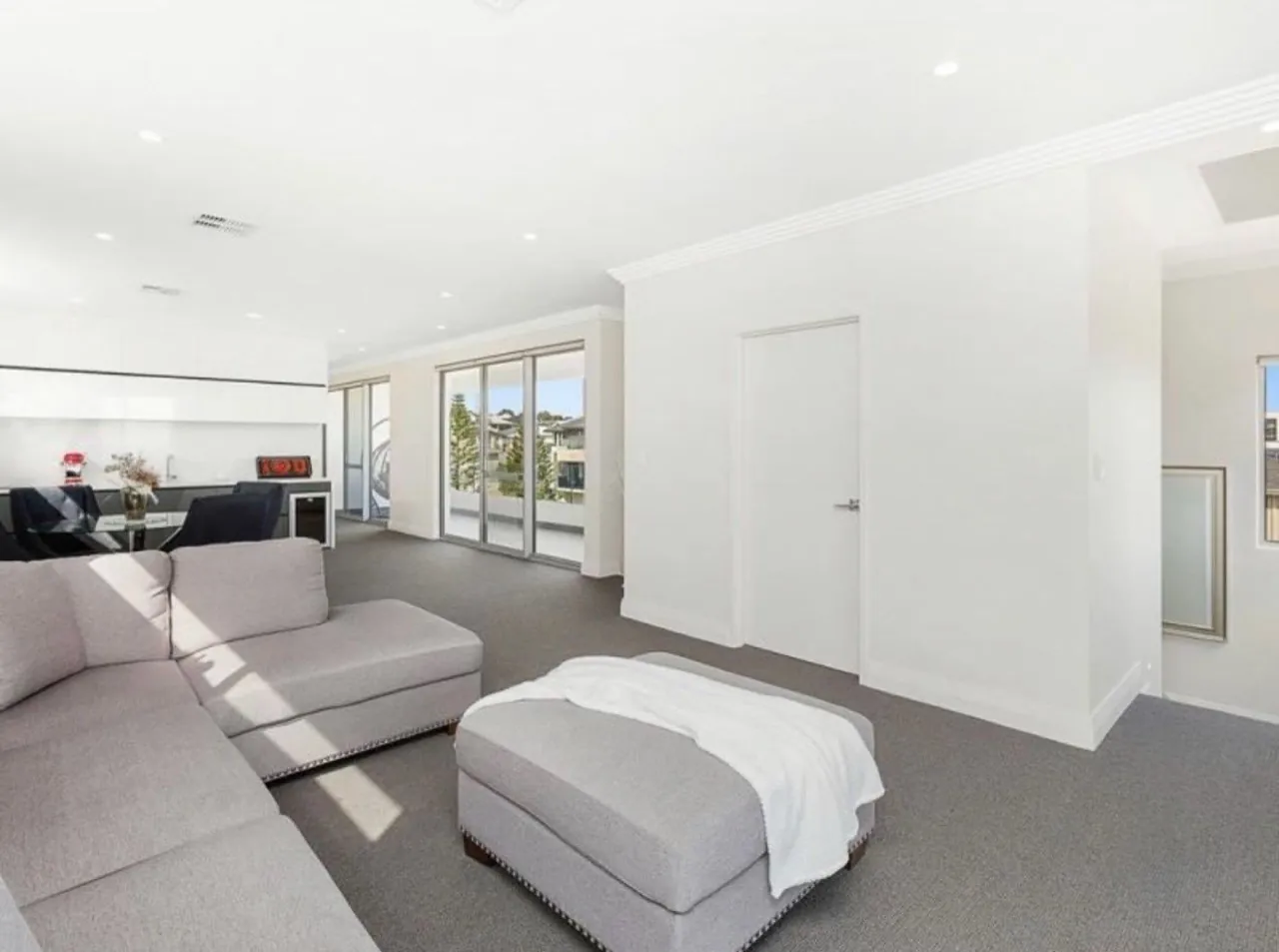 Open living area with bright white walls, ceilings and doors